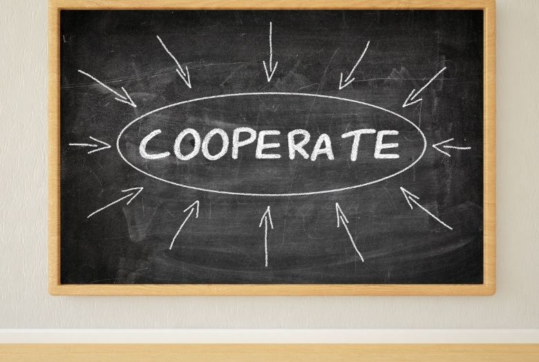Quadro nego escrito "cooperar! em inglês